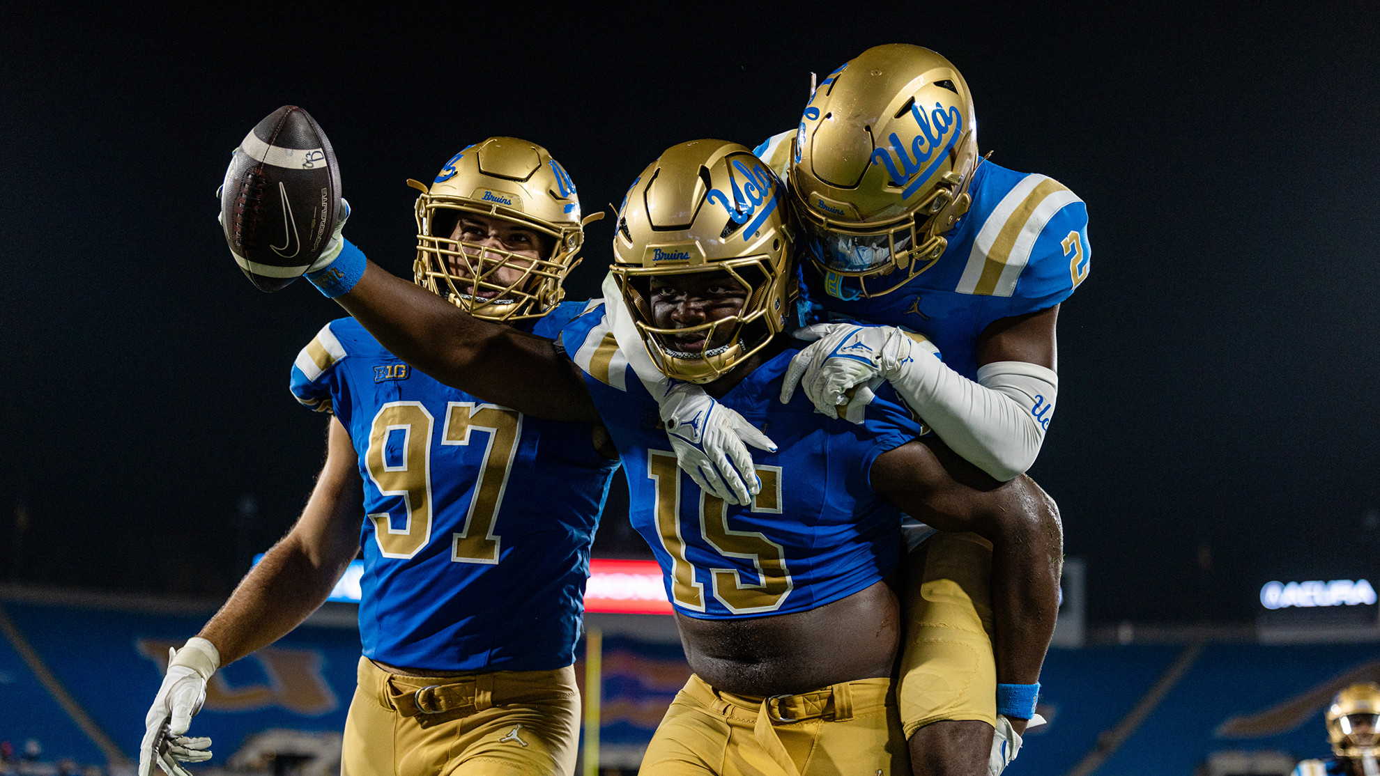 UCLA defensive lineman Sahir West celebrates with Aiden Gobaira and Rodrick Pleasant after a takeaway against Purdue